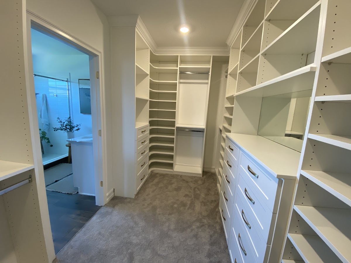 White walk-in closet with custom shelving and drawers connected to master bath in Bradenton FL